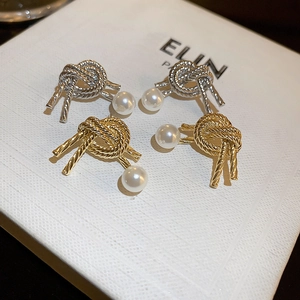 Knot metal pearl earrings set in gold and silver finish for a vintage minimalist look