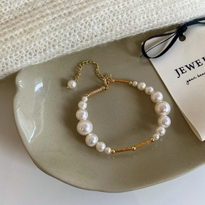 Close-up of pearl bracelet with gold metal spacers and adjustable clasp on elegant tray