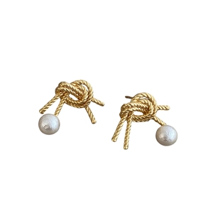 Elegant gold knot stud earrings with white pearls for a minimalist vintage look