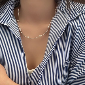 Elegant freshwater pearl necklace with silver rope chain shown on a model's neck
