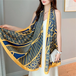 Detail of silk scarf showing yellow and navy contrast with chain and letter pattern