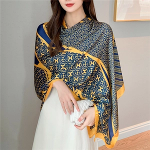 Detail view of navy blue and yellow silk shawl with H-letter geometric pattern print