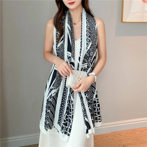 Close-up of long silk scarf featuring black and white geometric chain print pattern
