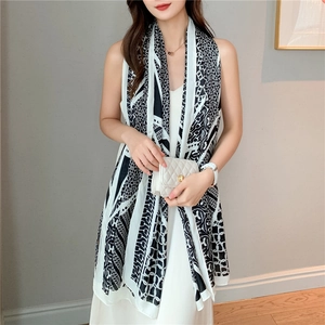 Detail of elegant black and white silk scarf with chain print and chic letter patterns