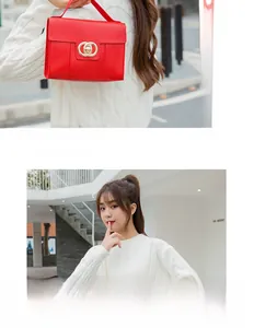 Detail of red crocodile embossed handbag with golden ring buckle and chain strap
