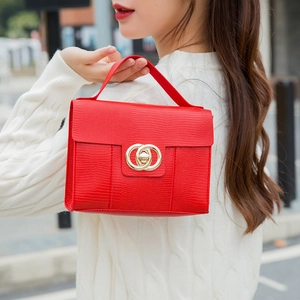 Elegant red crocodile texture crossbody bag with iconic gold hardware on a white sweater