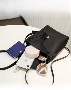 Spacious interior of black bucket bag showing storage for phone, umbrella and cosmetics