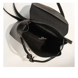 Top view of spacious main compartment in black faux leather drawstring backpack