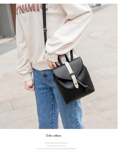 Detail of a black and white drawstring mini backpack worn by a model in outdoor lighting
