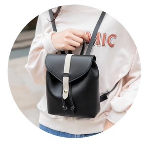 Detail of black mini backpack with contrast cream strap and gold hardware clasp