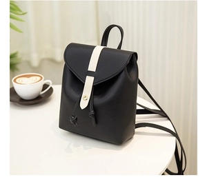 Detail of a black mini PU leather backpack with a gold buckle and white contrast strap