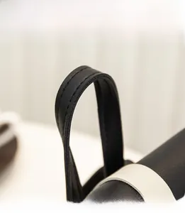 Detailed close-up of premium black leather handle with reinforced stitching on women bag