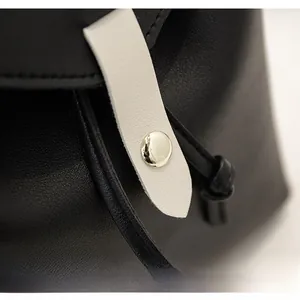 Close-up of contrast leather stitching with premium gold round metal buckle detail