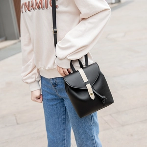 Women's black mini backpack with contrasting cream strap and gold buckle detail