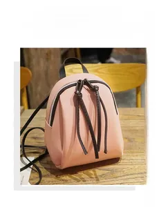 Dettaglio mini zaino rosa in ecopelle con tiri della cerniera lunghi marroni annodati