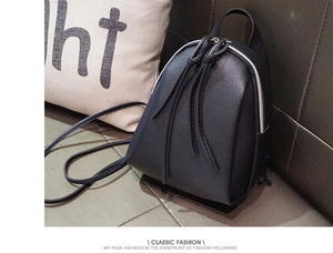 Dettaglio di un mini zaino nero con doppie cerniere argentate e texture in pelle PU
