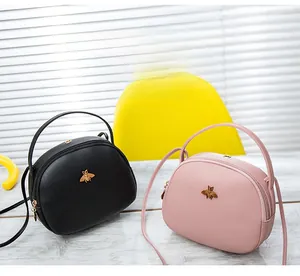 Détail des mini sacs bandoulière abeille en cuir PU grainé noir et rose
