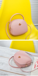 Détail du sac bandoulière rose semi-circulaire avec fermoir abeille dorée et zip
