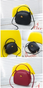 Détail d'un sac rond en cuir litchi avec ornement d'abeille dorée et bandoulière