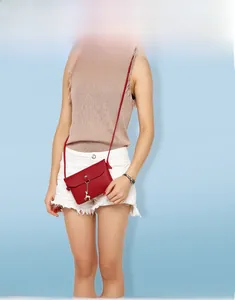 Red mini crossbody bag with golden deer pendant on a textured leather flap