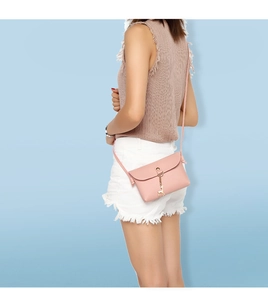 Close-up of pink mini crossbody bag with a delicate gold deer pendant on model