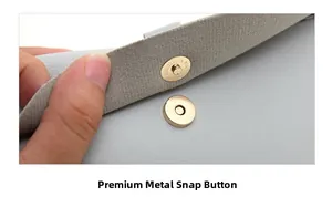 Detail of light gray leather bag featuring a polished gold magnetic metal snap closure