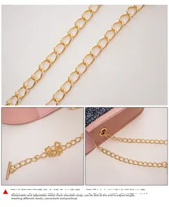 Détail du sac en cuir rose montrant la chaîne dorée et la boucle amovible de la sangle