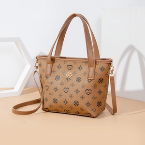 Brown monogrammed tote bag with heart patterns, dual handles and adjustable shoulder strap