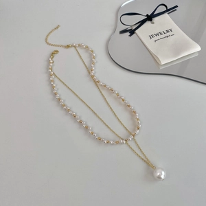 Elegant double-layered gold pearl necklace with large pendant and adjustable chain