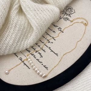 Détail macro du collier élégant en perles d'eau douce avec chaîne dorée ajustable