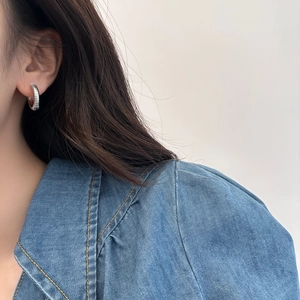 Chic silver ribbed hoop earrings for women shown on model with blue denim jacket