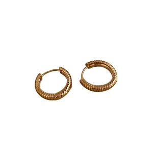 Golden ribbed hoop earrings featuring a vintage textured design on a white background