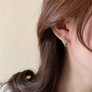 Minimalist heart zircon hoop earrings in gold plating shown on a female model