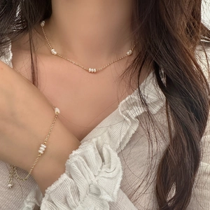 Détail de l'ensemble collier et bracelet en perles d'eau douce plaqué or sur mannequin