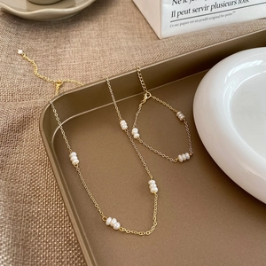Détail d'un ensemble collier et bracelet en perles d'eau douce sur plateau vintage