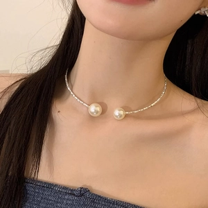 Close-up of elegant pearl choker necklace with polished silver beads on a female model