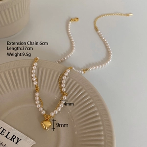 Detail of a pearl heart necklace showing a 9mm gold pendant and 4mm white pearls