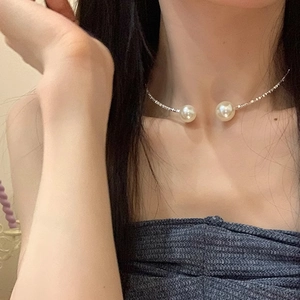 Minimalist silver choker necklace with large white pearls shown on collarbone