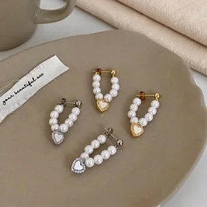 U-shaped pearl hoop earrings with shell heart charms in gold and silver plating