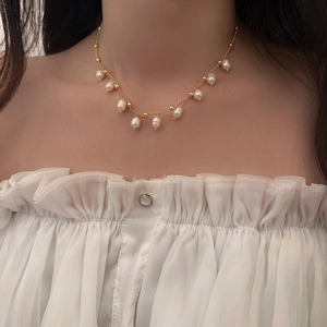 Detail of freshwater pearl tassel necklace on model showing gold chain and elegant luster
