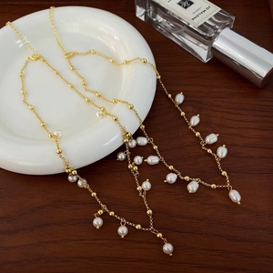 Vintage freshwater pearl tassel necklace with gold plating shown on elegant tabletop