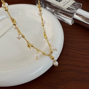 Detail shot of vintage freshwater pearl tassel necklace on white porcelain tray