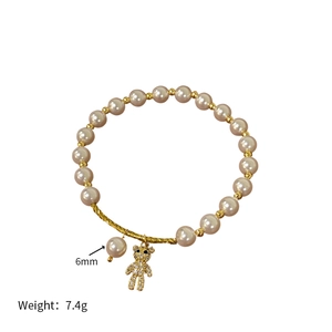 Detail of 6mm pearl bracelet featuring a sparkling gold bear pendant with 7.4g weight