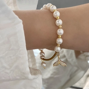 Elegant pearl bracelet with a sparkling zircon fishtail pendant shown on wrist
