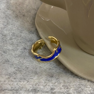 Detailed shot of vintage gold-plated ring with blue enamel texture on ceramic cup