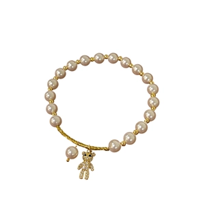 Elegant pearl bracelet with pink beads, gold-plated spiral accents and a teddy bear charm