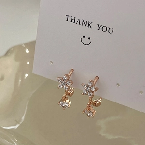 Detailaufnahme der roségoldenen Blumenohrringe mit Zirkonia auf einer Displaykarte