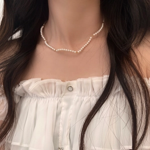 French style pearl necklace with gold spacer beads on a model's neck for elegant look