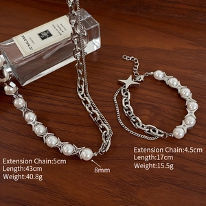 Detail of silver chain necklace with pearls and star pendant on a wood background