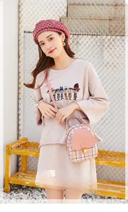 Detail of a pink plaid mini backpack with metal magnetic closure in a street fashion style